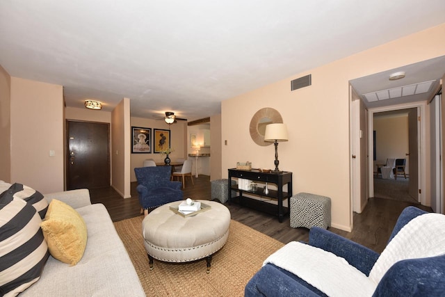 living room featuring ceiling fan and dark hardwood / wood-style flooring