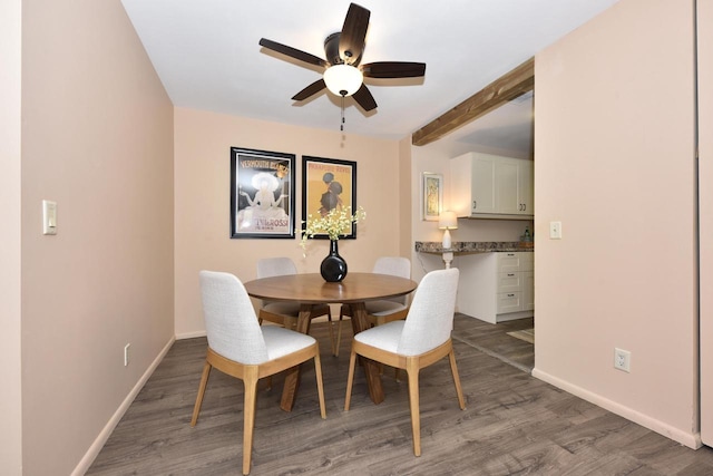 dining area with beamed ceiling, ceiling fan, and hardwood / wood-style floors