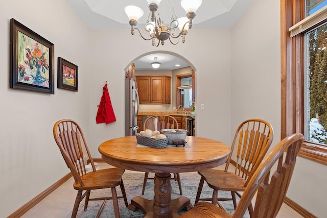 tiled dining space with a chandelier and sink