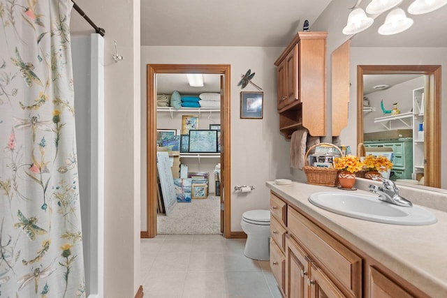 bathroom with vanity, walk in shower, tile patterned floors, and toilet