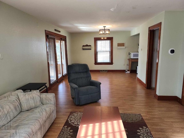 living room featuring hardwood / wood-style flooring, plenty of natural light, and an inviting chandelier