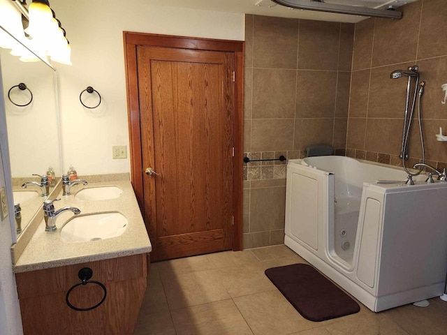 bathroom with a washtub, vanity, tile patterned floors, and tile walls