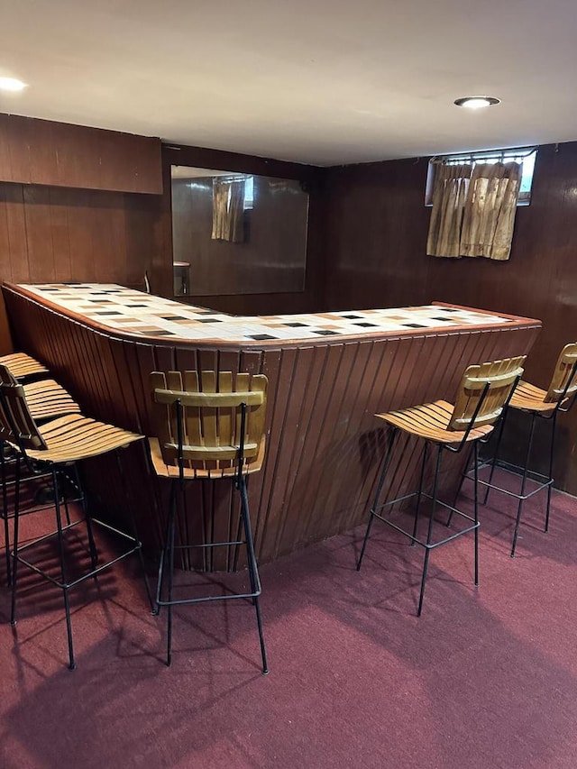 bar featuring carpet flooring and wood walls