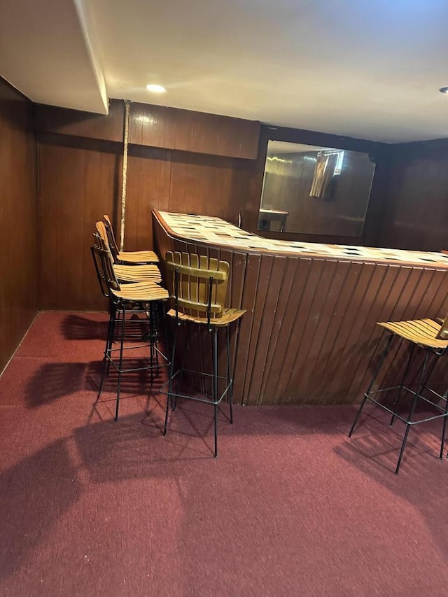 bar with carpet flooring and wood walls