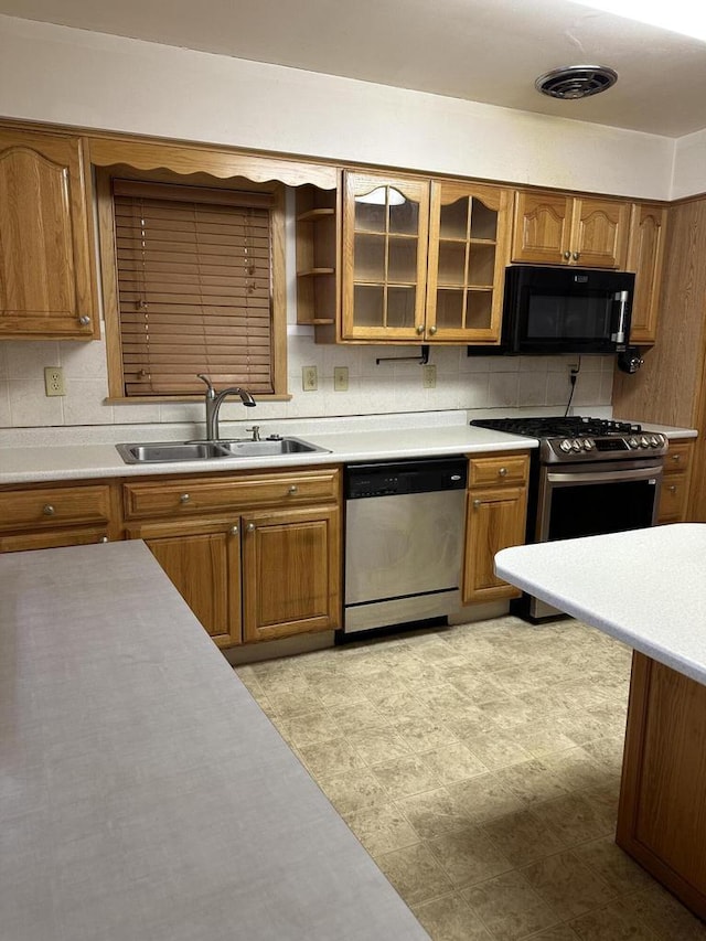 kitchen featuring appliances with stainless steel finishes, sink, and backsplash