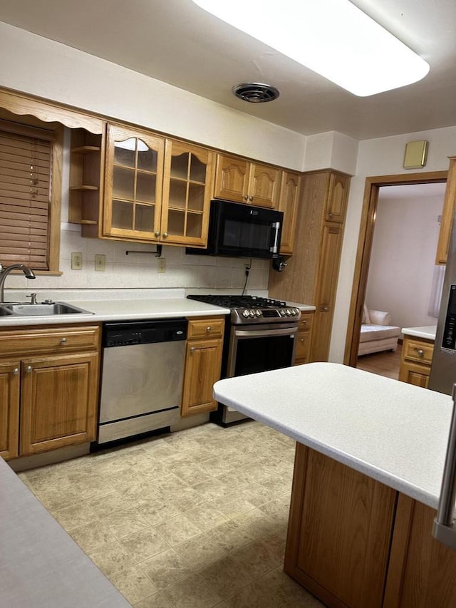 kitchen with sink, backsplash, and appliances with stainless steel finishes