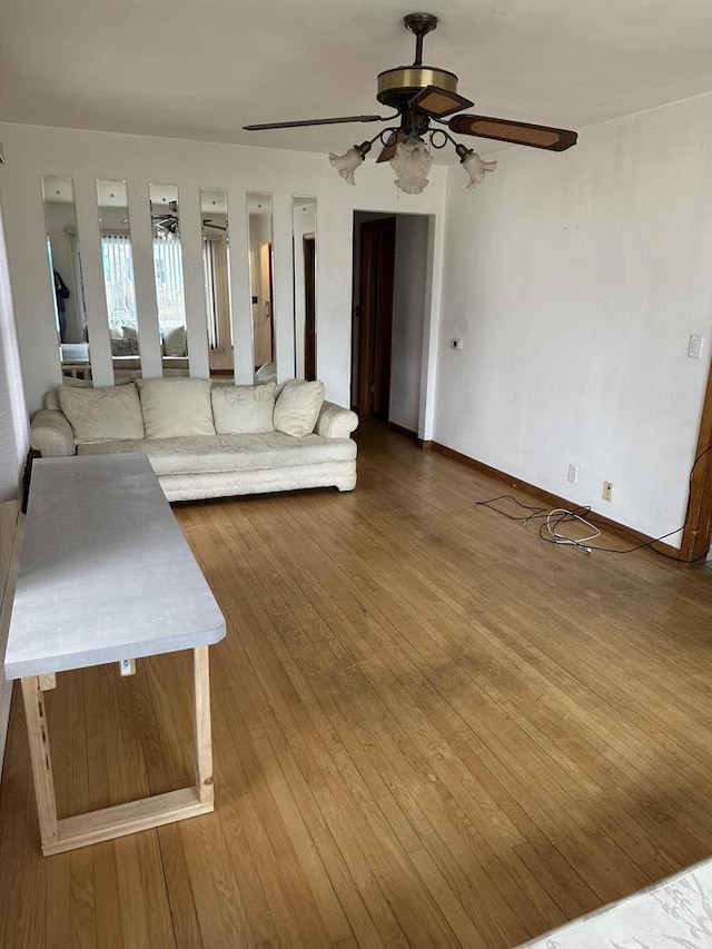 unfurnished living room featuring wood-type flooring and ceiling fan