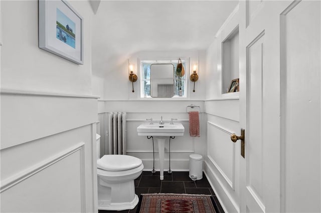 bathroom with radiator heating unit, toilet, and tile patterned flooring