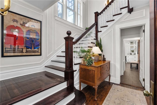 staircase featuring crown molding and wood-type flooring