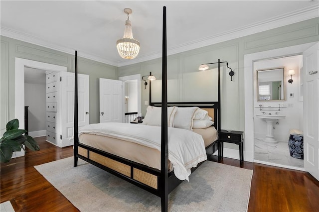 bedroom with ornamental molding, dark hardwood / wood-style floors, connected bathroom, and a notable chandelier