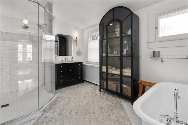 bathroom with a healthy amount of sunlight, separate shower and tub, and vanity