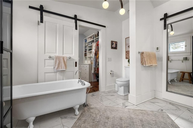 bathroom with a tub to relax in and toilet