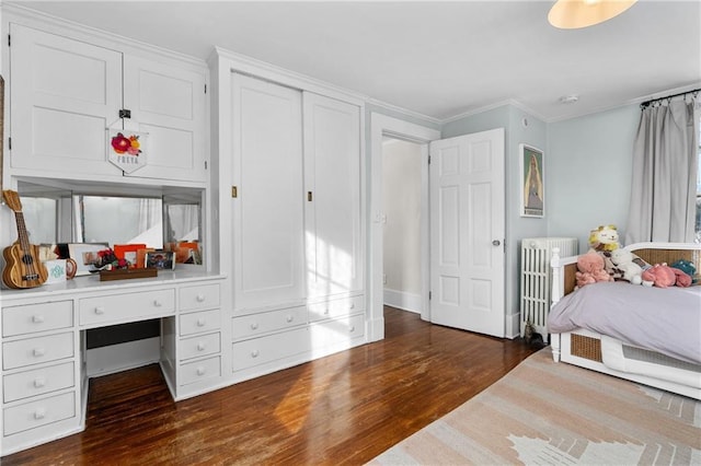 bedroom with crown molding, radiator heating unit, and dark hardwood / wood-style floors