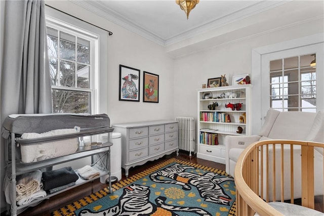 bedroom with ornamental molding, dark wood-type flooring, and radiator heating unit