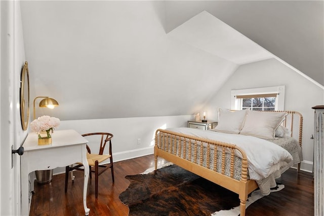 bedroom featuring lofted ceiling, refrigerator, and dark hardwood / wood-style flooring