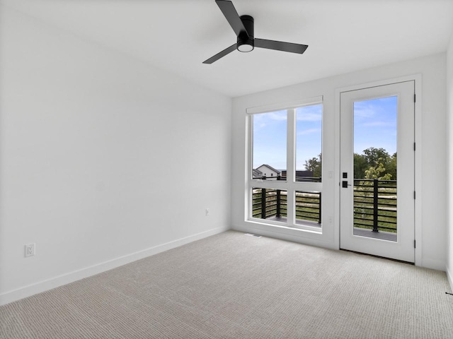 carpeted spare room featuring ceiling fan