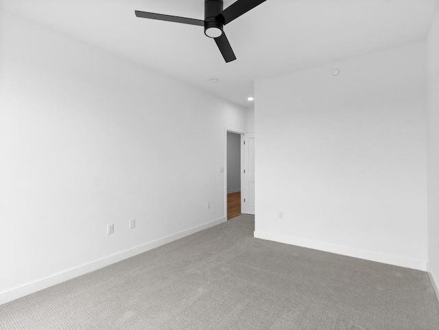 carpeted spare room featuring ceiling fan