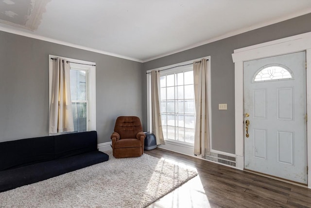 entrance foyer featuring dark wood-type flooring and ornamental molding