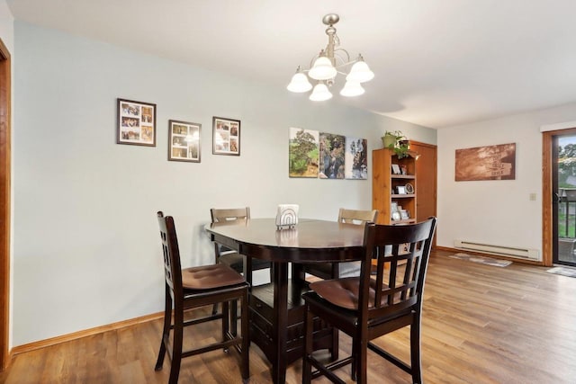 dining area featuring hardwood / wood-style flooring, an inviting chandelier, and baseboard heating