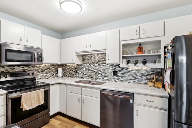 kitchen with white cabinetry, appliances with stainless steel finishes, sink, and backsplash