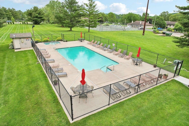 view of swimming pool featuring a yard, a shed, and a patio area