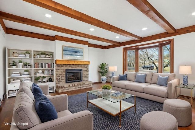 living room with dark hardwood / wood-style floors, beam ceiling, and a brick fireplace