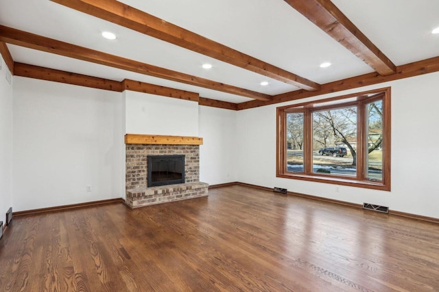 unfurnished living room with a fireplace, hardwood / wood-style floors, and beam ceiling