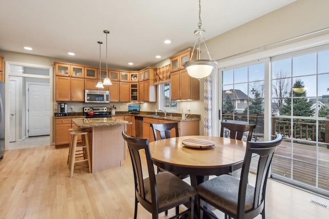 dining space with sink and light hardwood / wood-style floors