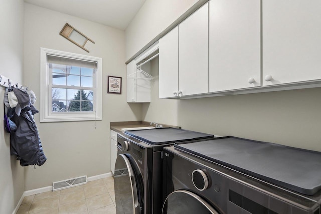 clothes washing area featuring sink, independent washer and dryer, light tile patterned floors, and cabinets