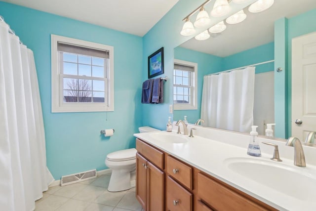 bathroom featuring tile patterned flooring, vanity, walk in shower, and toilet