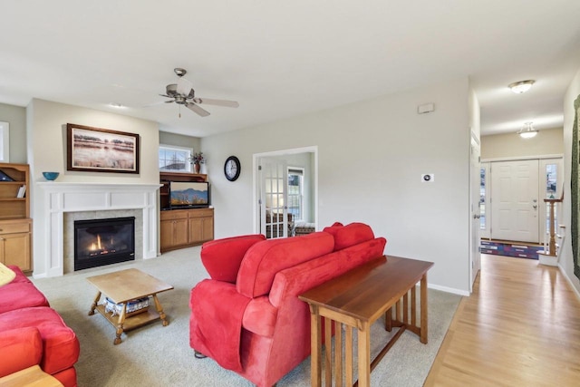 living room with light hardwood / wood-style flooring, a fireplace, and ceiling fan