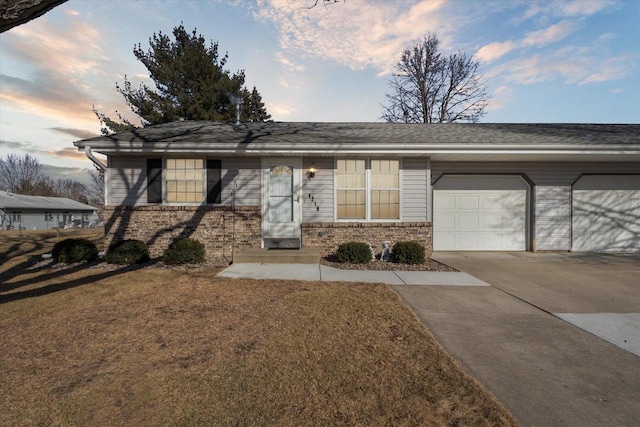 ranch-style home featuring a garage and a yard