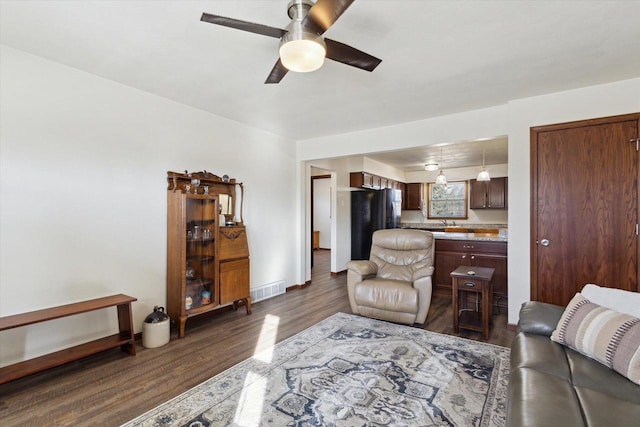 living room featuring ceiling fan, dark hardwood / wood-style floors, and sink