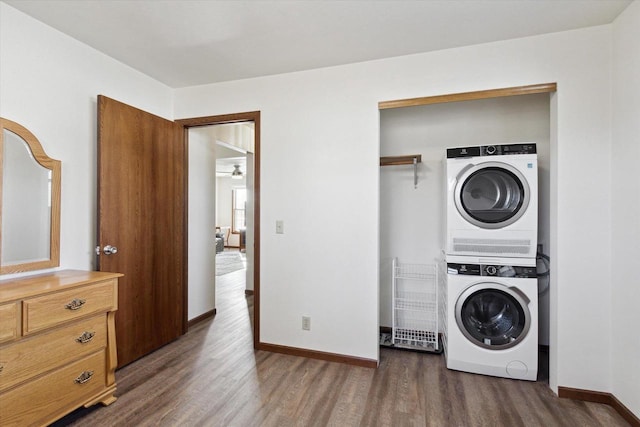 washroom with dark hardwood / wood-style floors and stacked washer and clothes dryer