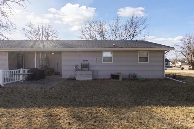 back of property with a yard, a patio area, and central air condition unit