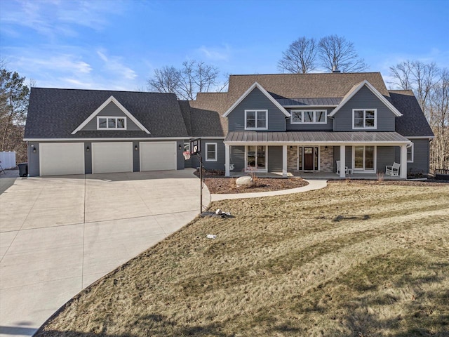 view of front of property featuring a garage, a front yard, and a porch