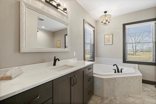 bathroom with tiled bath, vanity, tile patterned flooring, and a notable chandelier