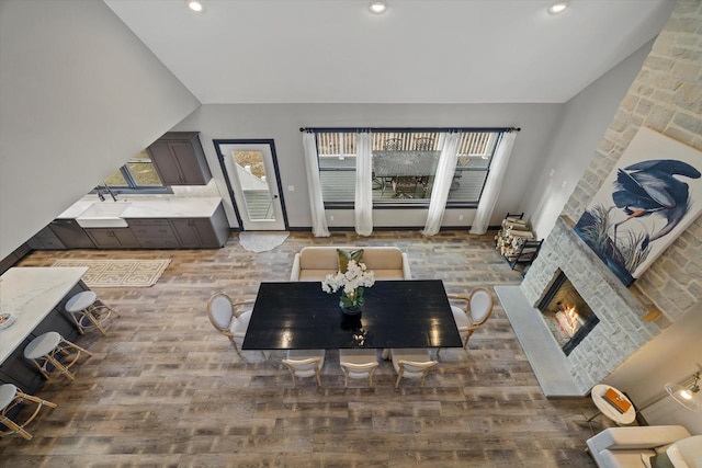 living room with vaulted ceiling, hardwood / wood-style flooring, and a fireplace