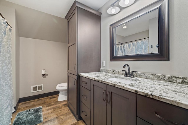 bathroom featuring toilet, wood-type flooring, and vanity