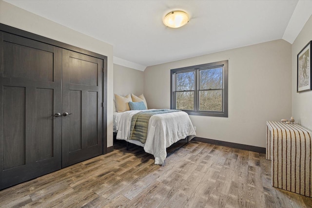 bedroom featuring light hardwood / wood-style flooring and lofted ceiling