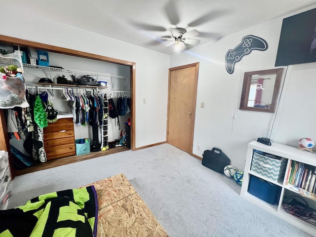 carpeted bedroom with ceiling fan and a closet