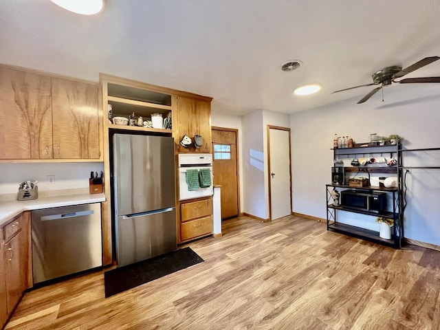 kitchen featuring stainless steel appliances, ceiling fan, and light wood-type flooring