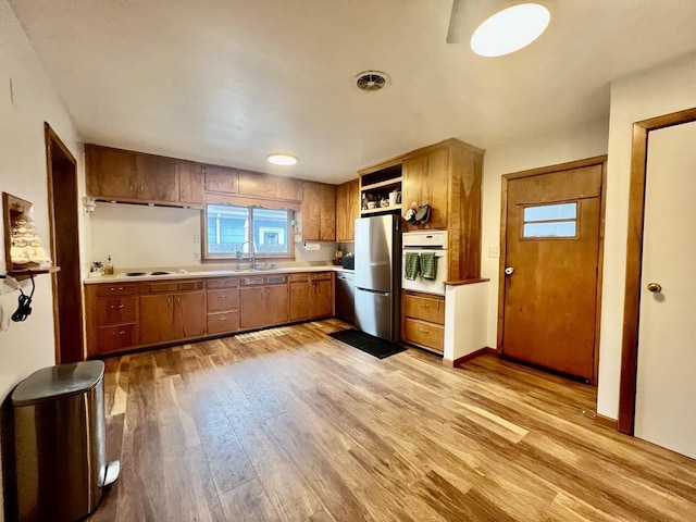 kitchen featuring sink, light wood-type flooring, and appliances with stainless steel finishes