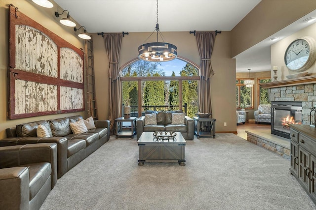 carpeted living room featuring an inviting chandelier, a stone fireplace, and a high ceiling