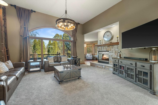 living room featuring carpet floors, a fireplace, a chandelier, and high vaulted ceiling