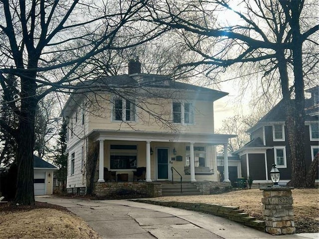 view of front facade featuring a garage, an outdoor structure, and covered porch