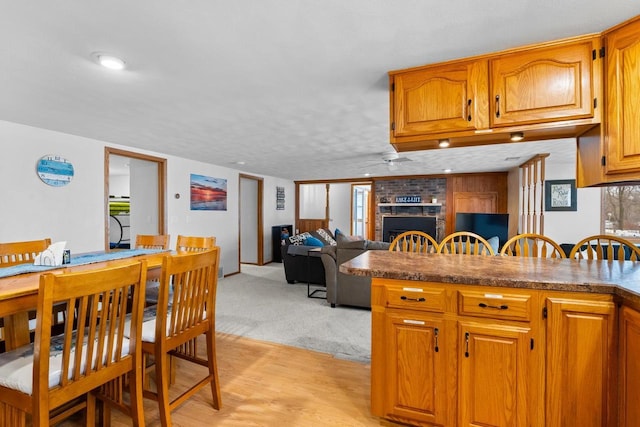 kitchen featuring a fireplace, light carpet, and a textured ceiling