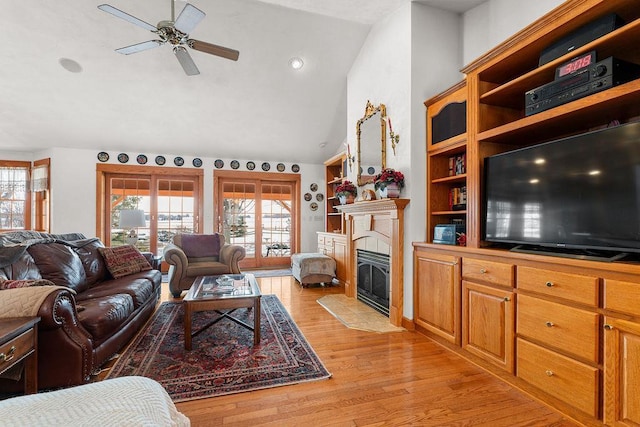 living room featuring light hardwood / wood-style flooring, plenty of natural light, lofted ceiling, and ceiling fan