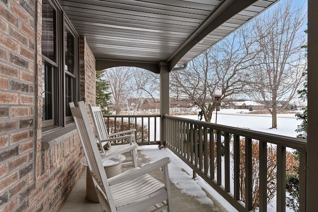 view of snow covered back of property