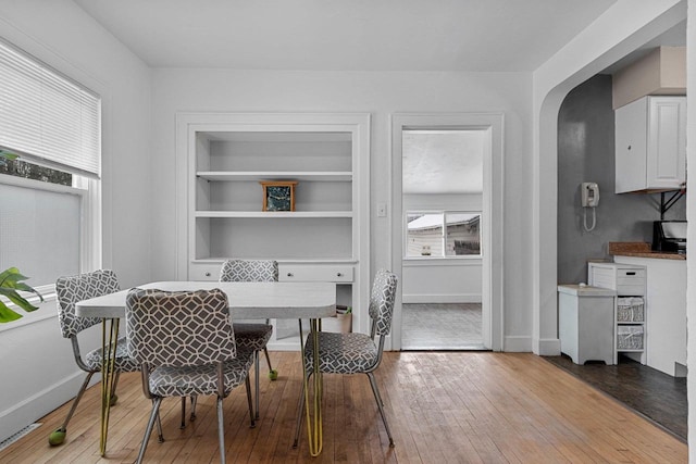 dining space with light hardwood / wood-style floors and built in features